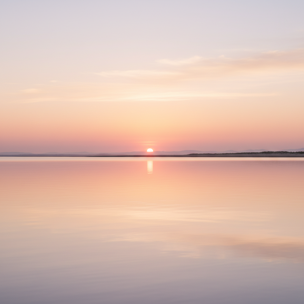 A soft, dreamy sunrise over calm water with warm pastel colors, evoking a peaceful, hopeful, emotionally safe feeling, minimal and uncluttered